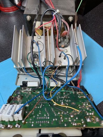 Inside a Palstar PSU. There is a large heat sink and a PCB in front of a transformer. 