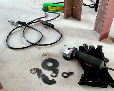 photo of angle grinder, broken cutoff wheels, welding gloves 