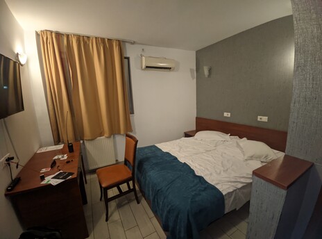 Hotel room with a desk, chair, double size bed, and AC. My D878UV talkie is on the desk.