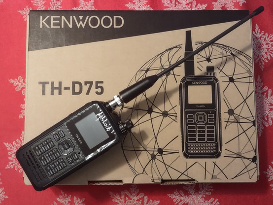 Kenwood TH-D75 handheld radio, on top of its box. 