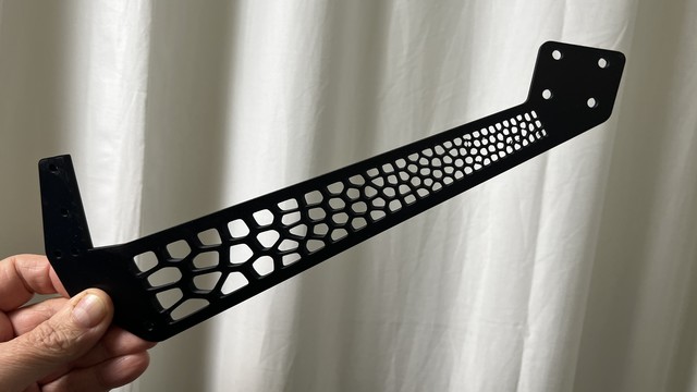 Carbon fibre-filled flat support 5mm thick 230 mm long max 50mm wide 3D printed from carbon-fibre filled PLA. There are four mounting holes in a rectangle arrangement for an antenna feedhorn.