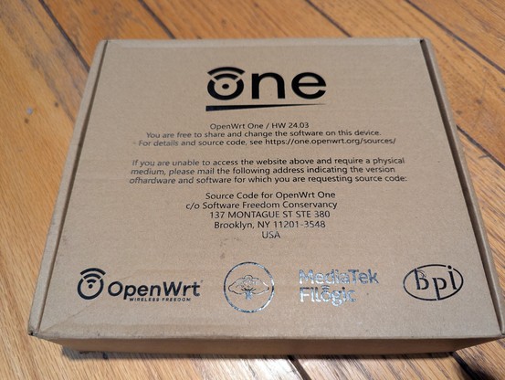 The box in which the OpenWRT One is shipped. Tells you where to get the source code.