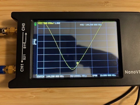 Photo of NanoVNA-H4 measuring VSWR of the DIY 2 meter Halo antenna. VSWR is 1.36:1 at 144.200 MHz fed with a 12 foot length of RG-58C coax.