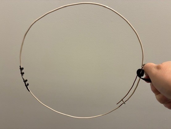 Holding overhead photograph of the DIY 2 meter Halo antenna. Antenna is about 12 inches in diameter.