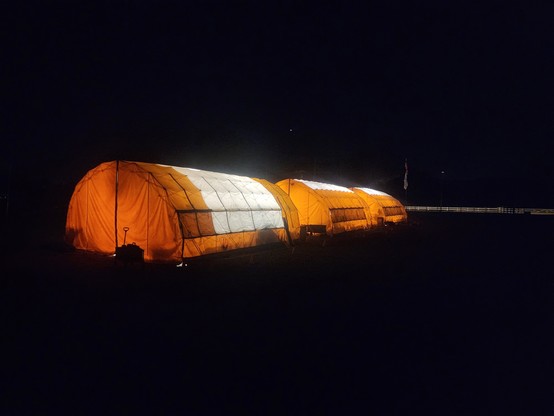 Tents used by Conejo Valley Amateur Radio Club for #2025FieldDay, lit from within at night